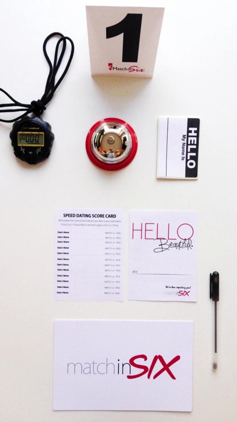 The Original Speed Dating Kit laid out: table number, bell, timer, score cards, name tags